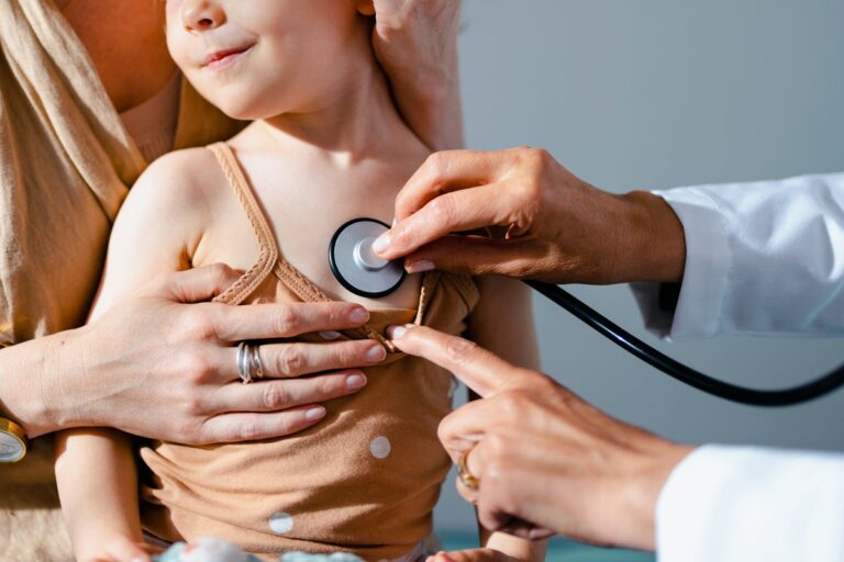 doctor examining child on parents lap